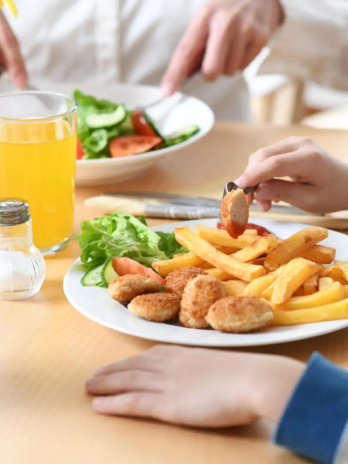 19.03.2019, Bayern, München: ILLUSTRATION: Ein Junge sitzt vor einem Teller mit Chicken Nuggets und Pommes Frites (gestellte Szene). Kleines Schnitzel mit Pommes, Fischstäbchen oder Spaghetti - für Kinder gibt es in Restaurants oft nicht nur kleinere Portionen, sondern auch nicht besonders gesunde Gerichte. Foto: Tobias Hase/dpa