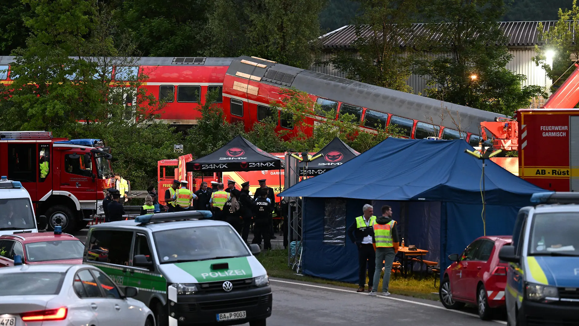 03.06.2022, Bayern, Garmisch-Partenkirchen: Zahlreiche Einsatz- und Rettungskräfte bereiten die Unglücksstelle für den weiteren Einsatz in der Nacht vor. Bei einem schweren Zugunglück sind in Garmisch-Partenkirchen mindestens vier Menschen ums Leben gekommen. Ein Regionalexpress entgleiste in der beliebten oberbayerischen Urlaubsregion auf dem Weg von Garmisch nach München. Foto: Angelika Warmuth/dpa +++ dpa-Bildfunk +++
