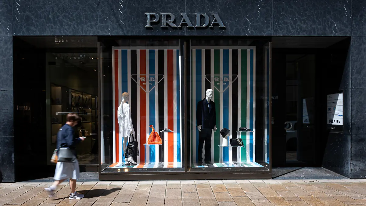 PRODUKTION - 27.05.2022, Hamburg: Eine junge Frau geht an einer Boutique des Modeunternehmens Prada vorbei. Luxusmode richtet sich längst nicht mehr nur an wohlhabende Menschen. Bei der jungen Generation werden teure Luxusmarken immer beliebter. (zu dpa «Luxusmode bei jungen Menschen beliebt - Woher der Trend kommt») Foto: Daniel Reinhardt/dpa +++ dpa-Bildfunk +++