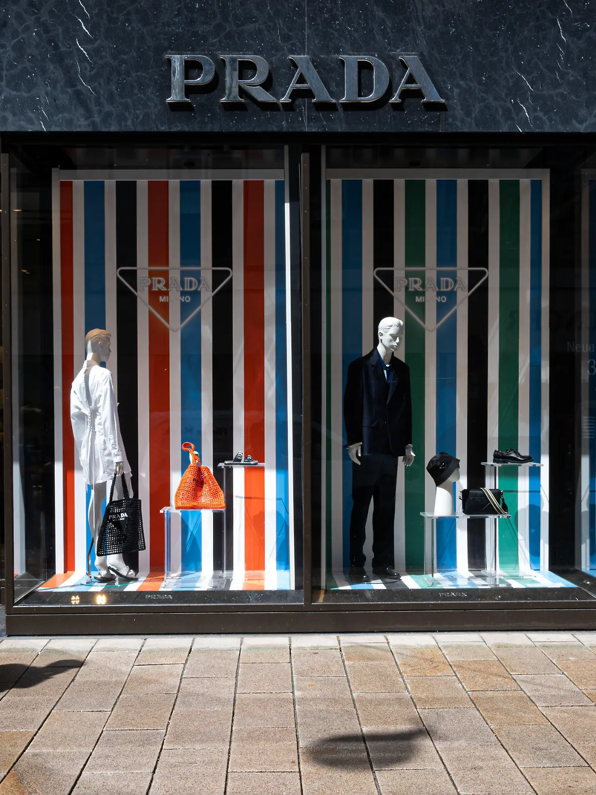 PRODUKTION - 27.05.2022, Hamburg: Eine junge Frau geht an einer Boutique des Modeunternehmens Prada vorbei. Luxusmode richtet sich längst nicht mehr nur an wohlhabende Menschen. Bei der jungen Generation werden teure Luxusmarken immer beliebter. (zu dpa «Luxusmode bei jungen Menschen beliebt - Woher der Trend kommt») Foto: Daniel Reinhardt/dpa +++ dpa-Bildfunk +++