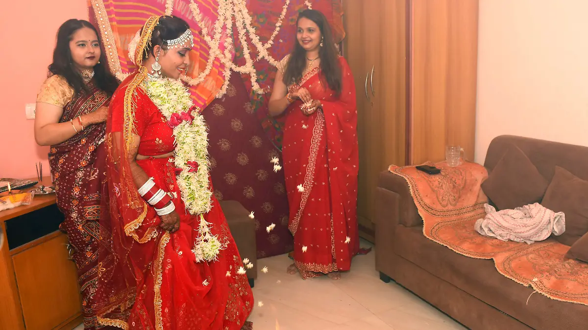 08.06.2022, Indien, Vadodara: Kshama Bindu (M) vollzieht Rituale während ihrer Selbsthochzeit in ihrem Haus. Die Bloggerin aus Indien hat sich symbolisch selbst geheiratet. Dabei absolvierte sie in einem typisch roten Hochzeitskleid die üblichen Rituale, die bei hinduistischen Hochzeiten dazugehören - nur ohne Mann und ohne Priester. Foto: Str/AP/dpa +++ dpa-Bildfunk +++