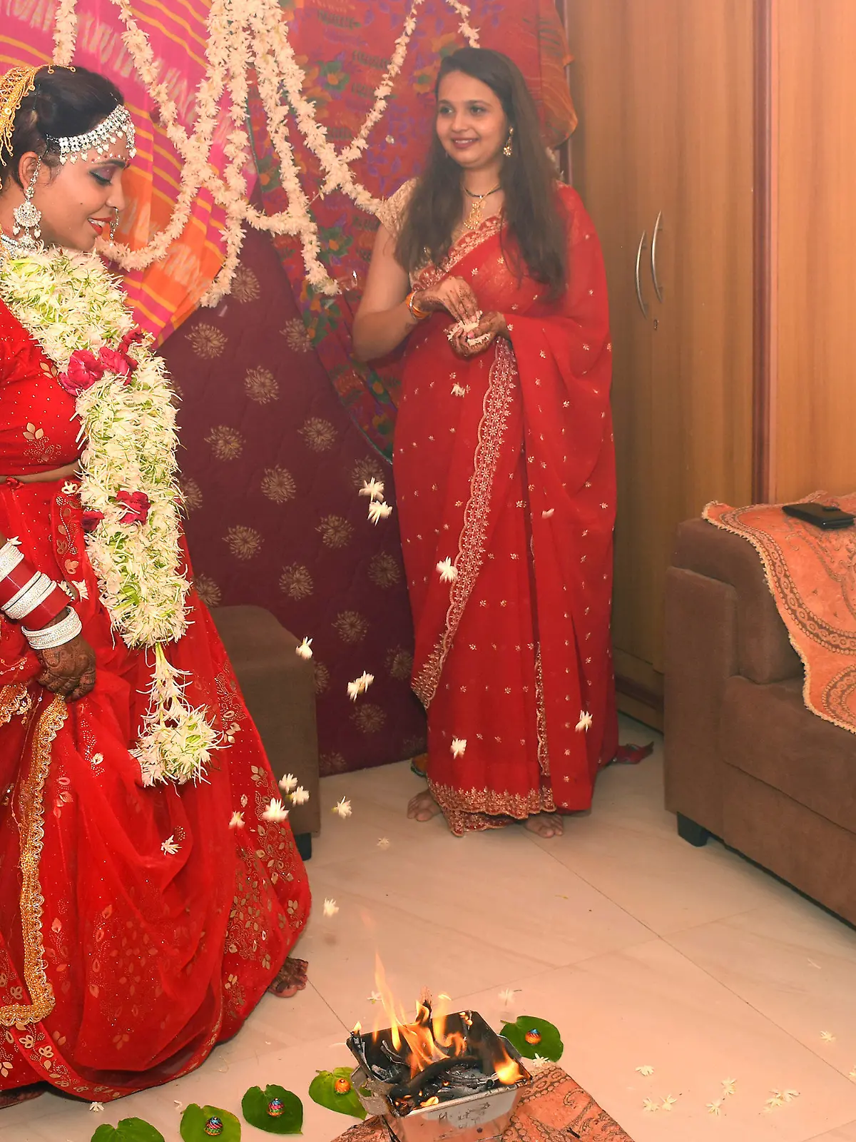08.06.2022, Indien, Vadodara: Kshama Bindu (M) vollzieht Rituale während ihrer Selbsthochzeit in ihrem Haus. Die Bloggerin aus Indien hat sich symbolisch selbst geheiratet. Dabei absolvierte sie in einem typisch roten Hochzeitskleid die üblichen Rituale, die bei hinduistischen Hochzeiten dazugehören - nur ohne Mann und ohne Priester. Foto: Str/AP/dpa +++ dpa-Bildfunk +++