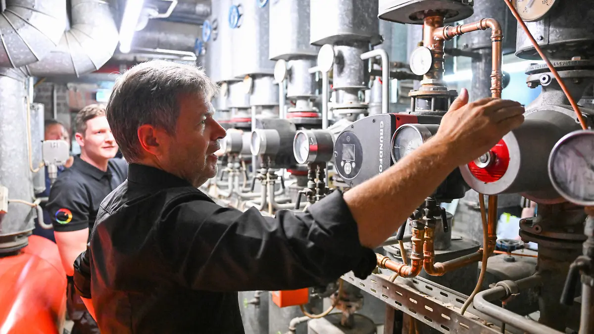 11.07.2023, Nordrhein-Westfalen, Köln: Robert Habeck (r, Bündnis 90/Die Grünen), Bundesminister für Wirtschaft und Klimaschutz, läßt sich auf seiner Sommerreise in dem Handwerksbetrieb Temperaturwerk für Heiztechnik von dem Geschäftsführer Marco Goetzke (l) in einem Heizungskeller moderne Heiztechnik erklären. Foto: Bernd Weißbrod/dpa +++ dpa-Bildfunk +++