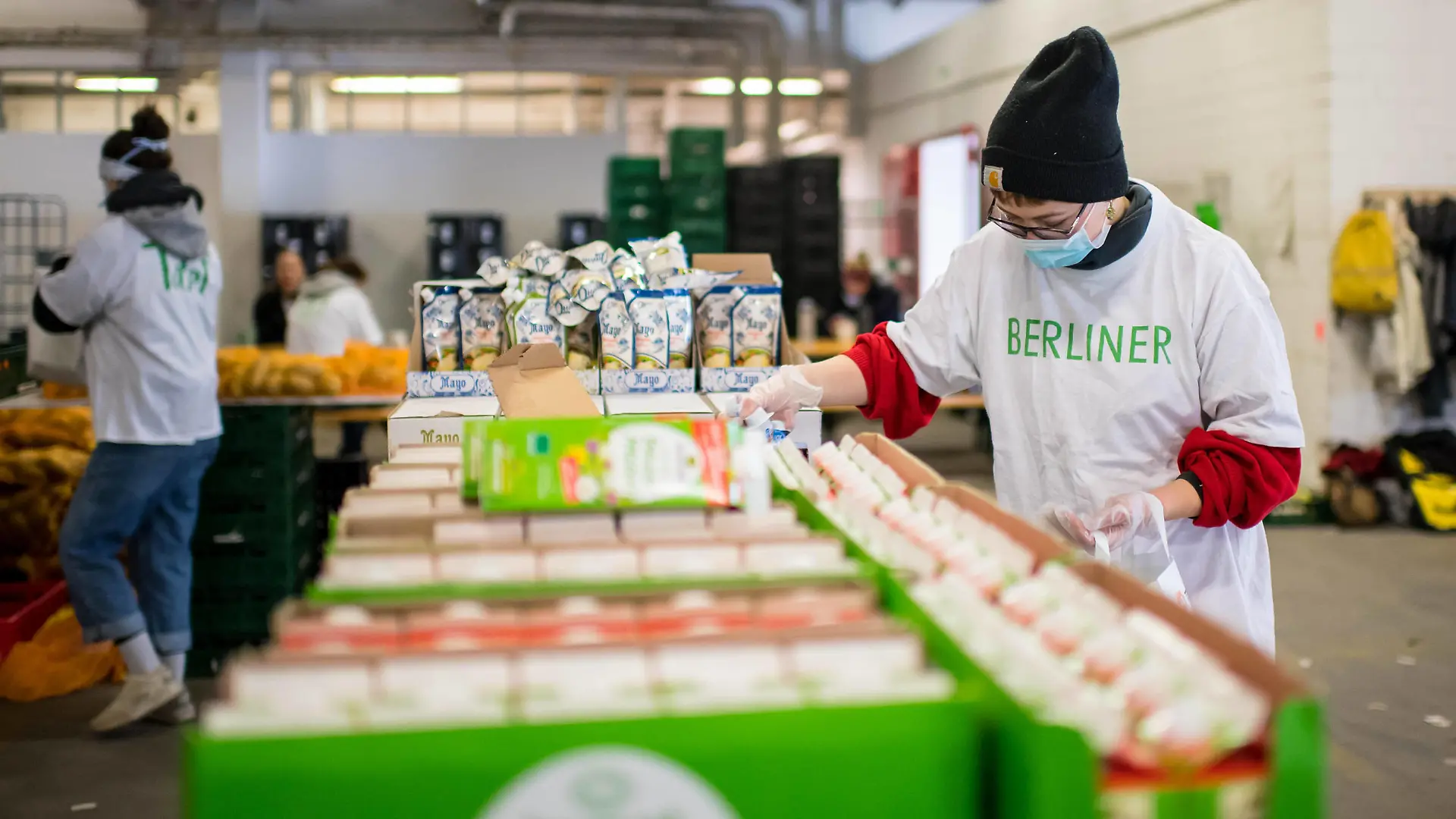 Berlin Corona-Krise Berliner Tafel Auswirkungen der Corona-Krise. Die Corona-Situation hat auch fuer die Hilfsorganisation Berliner Tafel weitreichende Konsequenzen. 42 LAIB und SEELE-Ausgabestellen mussten schliessen, nur drei der Ausgabestellen haben noch geoeffnet. Rund 50.000 beduerftige Menschen kommen ueblicherweise jeden Monat an den Ausgabestellen. Damit die Menschen weiterhin gespendete Lebensmittel erhalten koennen, beliefert die Berliner Tafel nun die Menschen zu Hause. In einer Halle auf dem Berliner Grossmarkt packen freiwillige Helferinnen und Helfer Tueten mit Lebensmitteln im Bild, die verteilt werden. In einigen Bezirken uebernehmen Radfahrerinnen und Radfahrer der Rebel Riders mit Lastenraedern die Vor-Ort-Verteilung von Tuer zu Tuer. LAIB und SEELE ist eine Aktion der Berliner Tafel e.V., der Kirchen u