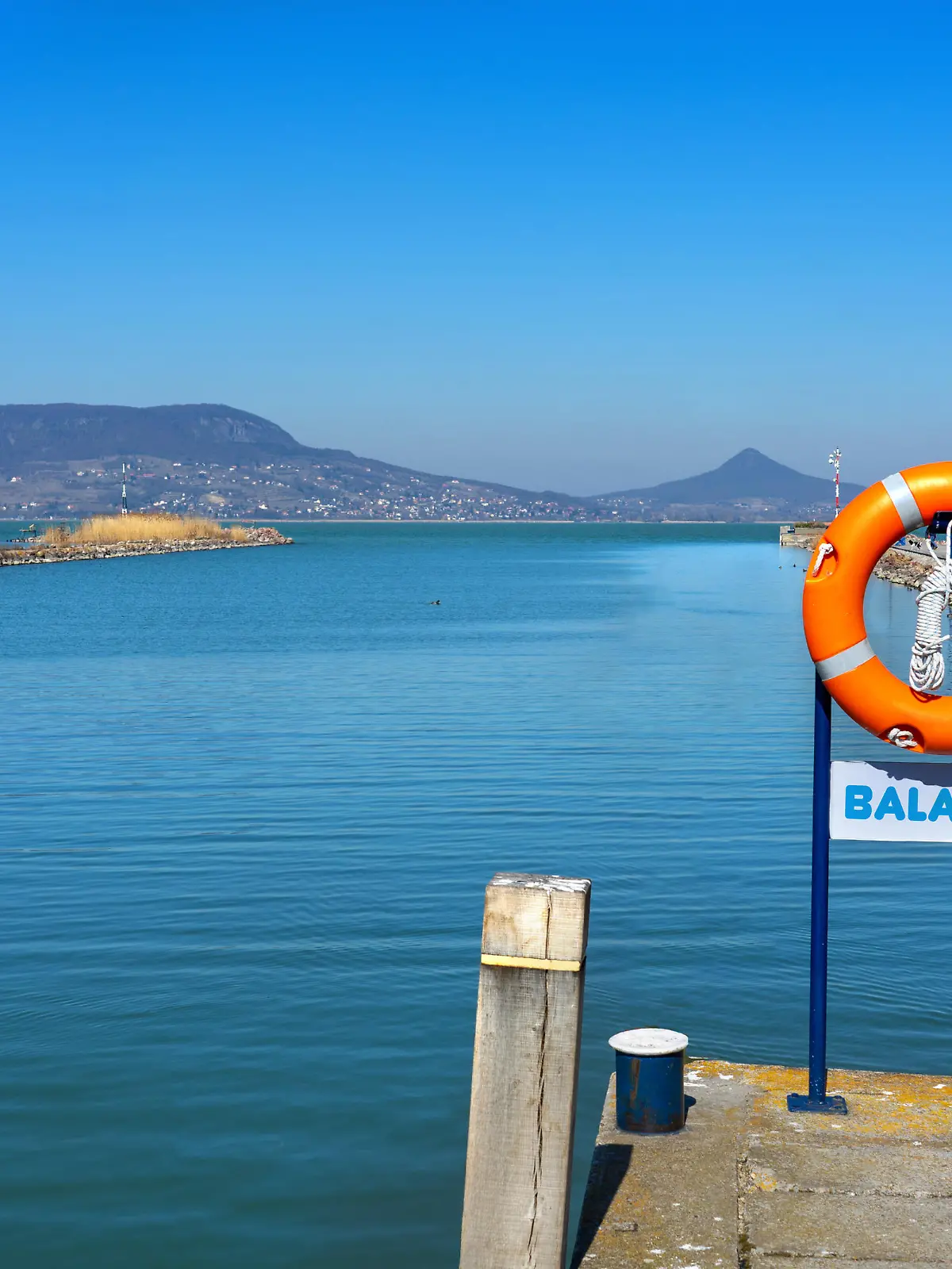 idillic landscape of lake Balaton from Fonyod Hungary with Badacsony hill in the background and Balaton sign board .