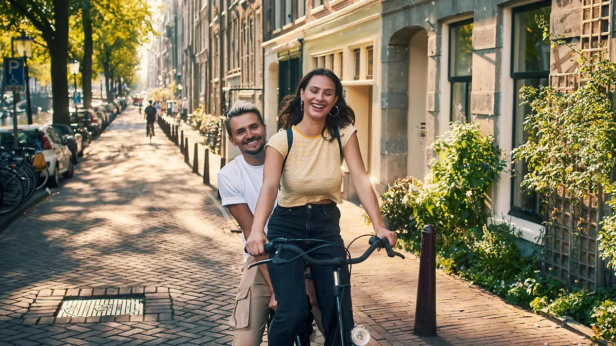 Shot of a young couple exploring the city of Amsterdam by bike