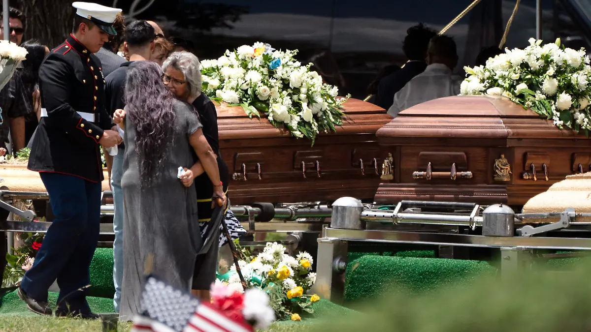 Two women comfort each other during the burial service for Irma Garcia and her husband Joe Garcia at Hillcrest Cemetery, Wednesday, June 1, 2022, in Uvalde, Texas. Irma Garcia was killed in last week's elementary school shooting. Joe Garcia died two days later. (AP Photo/Jae C. Hong)