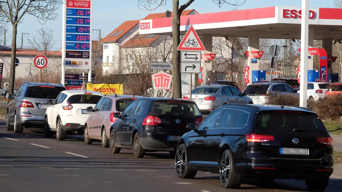Autos stehen in einer Schlange vor einer Tankstelle, deren Preise niedriger sind als der Tagesdurchschnitt.