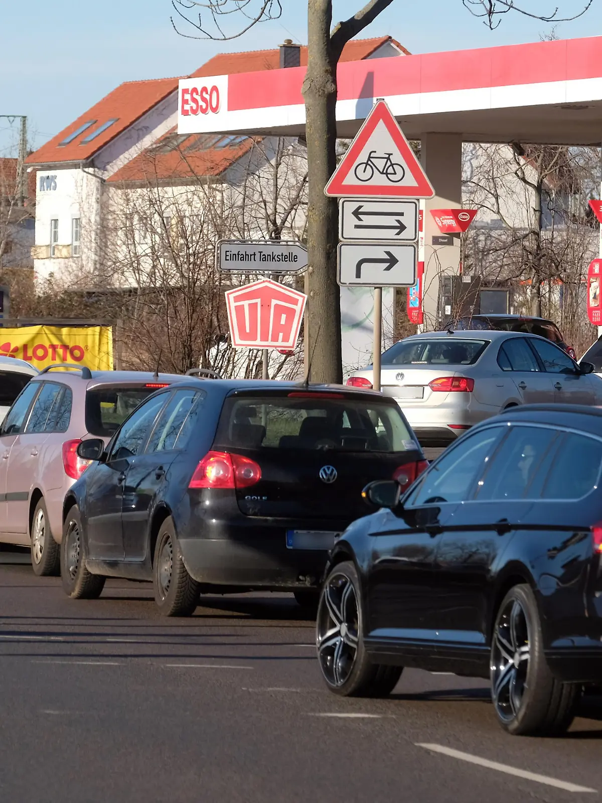 Autos stehen in einer Schlange vor einer Tankstelle, deren Preise niedriger sind als der Tagesdurchschnitt.