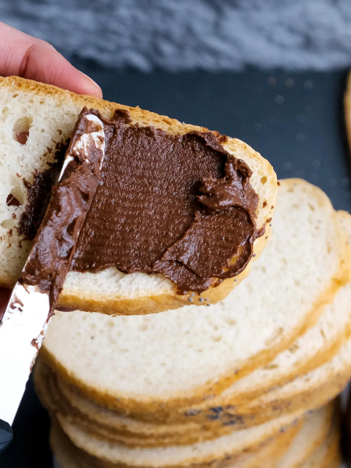 Sweet chocolate cream in jar on table. Nutella with buttered bread