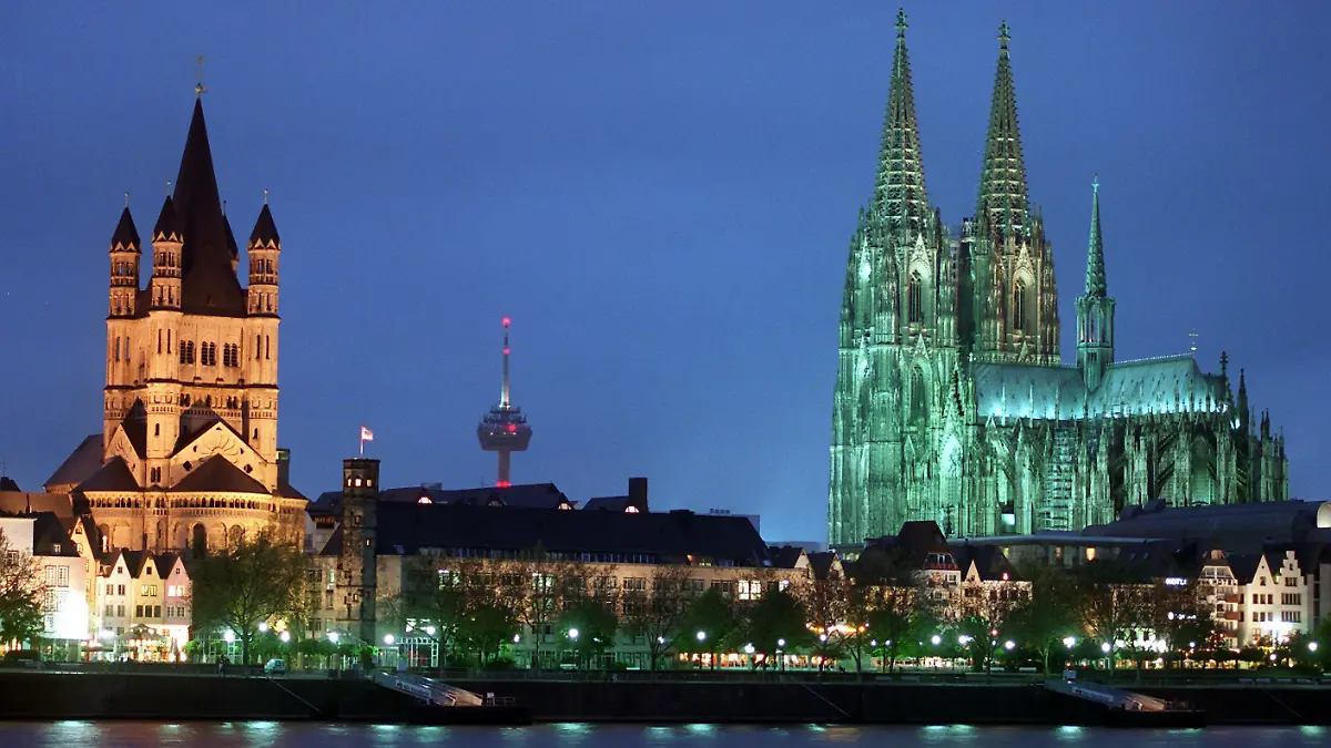 Mit Einbruch der Dunkelheit wird das Wahrzeichen der Stadt, der Hohe Dom zu Köln (r, Bild von Mittwoch, 06.05.1998) von zahlreichen Scheinwerfern ins rechte Licht gerückt. Der imposante Sakralbau, dessen Grundstein am 12. August 1248 gelegt wurde, feiert in diesem Jahr sein 750. Bestehen. Das ganze Jahr hindurch wird des historischen Termins in Ausstellungen, Feiern und Gottesdiensten gedacht. Zusammen mit der Kirche Groß St. Martin (l) und ist die Altstadtkulisse am Rheinuferein beliebtes Fotomotiv. dpa COLORplus