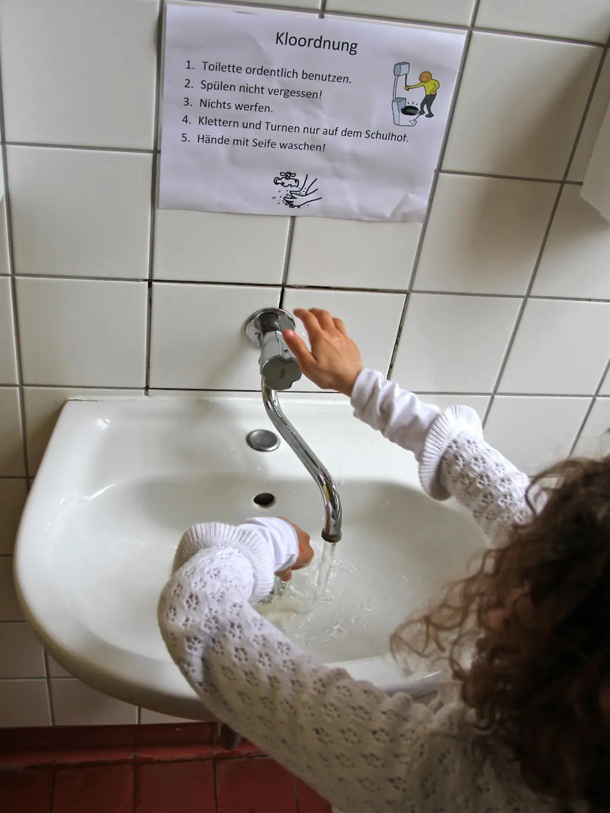 Eine Schülerin wäscht sich die Hände in einem WC in der Grundschule am «Weißen See» am 23.04.2013 in Berlin. In vielen Schulen fehlt das Geld für eine Sanierung der Schulklos. Foto: Stefan Schaubitzer/dpa (zu dpa KORR: «Problemfall Schultoilette - Für die Sanierung fehlt das Geld» vom 25.04.2013)