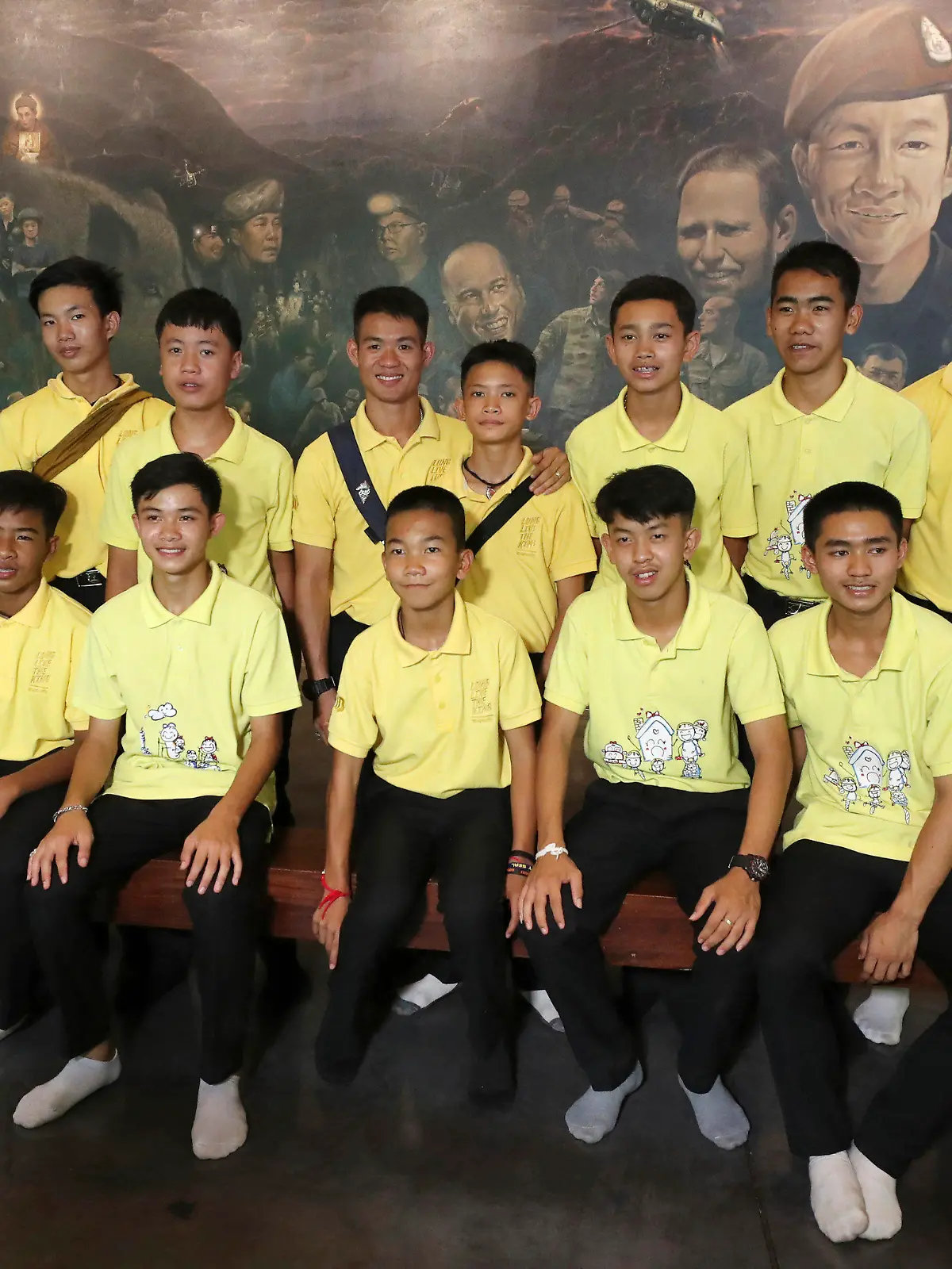 24.06.2019, Thailand, Mae Sai: Die 12 Jungs der Fußballmannschaft der «Wildschweine» aus Mae Sai und ihr ehemalige Fußballtrainer Ekkapol Chanthawong (4.v.l, hintere Reihe), die zusammen vor einem Jahr aus der überfluteten Tham-Luang-Höhle gerettet wurden, lassen sich bei einer Pressekonferenz zusammen fotografieren. Foto: Sakchai Lalit/AP/dpa +++ dpa-Bildfunk +++