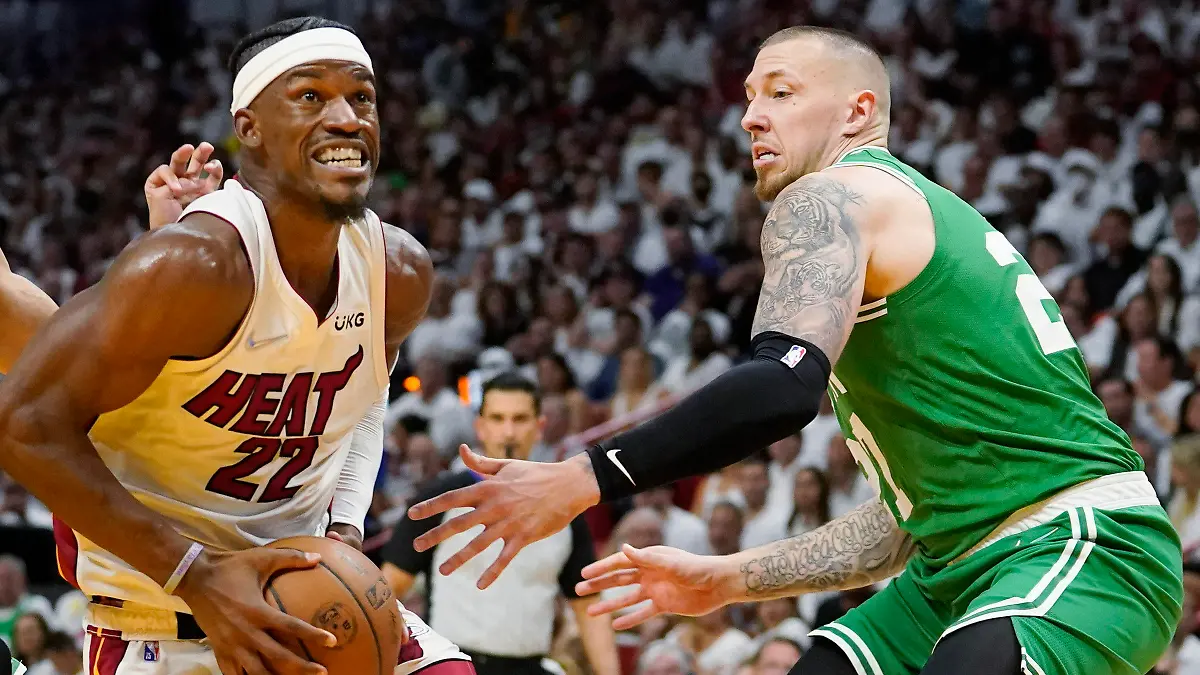 Miami Heat forward Jimmy Butler (22) drives to the basket between Boston Celtics guard Derrick White (9) and center Daniel Theis (27) during the second half of Game 1 of an NBA basketball Eastern Conference finals playoff series, Tuesday, May 17, 2022, in Miami. (AP Photo/Lynne Sladky)