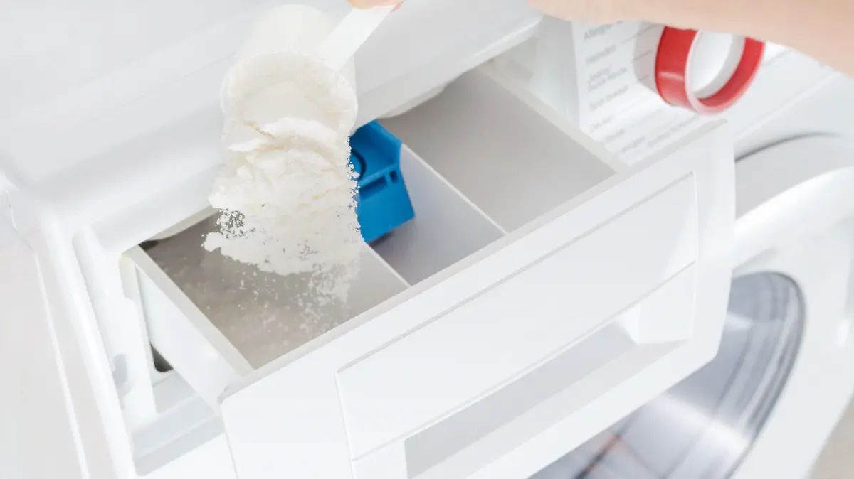 washing powder, detergent in a cup and womans hand, selective focus, washing machine, closeup