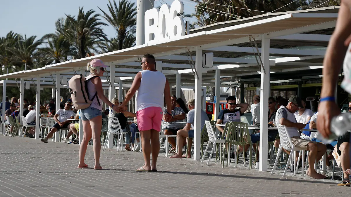 13.05.2022, Spanien, Palma: Menschen gehen am Ballermann 6 am Strand von Arenal vorbei. Der Ballermann auf Mallorca feiert sein 50-jähriges Jubiläum. Foto: Clara Margais/dpa +++ dpa-Bildfunk +++