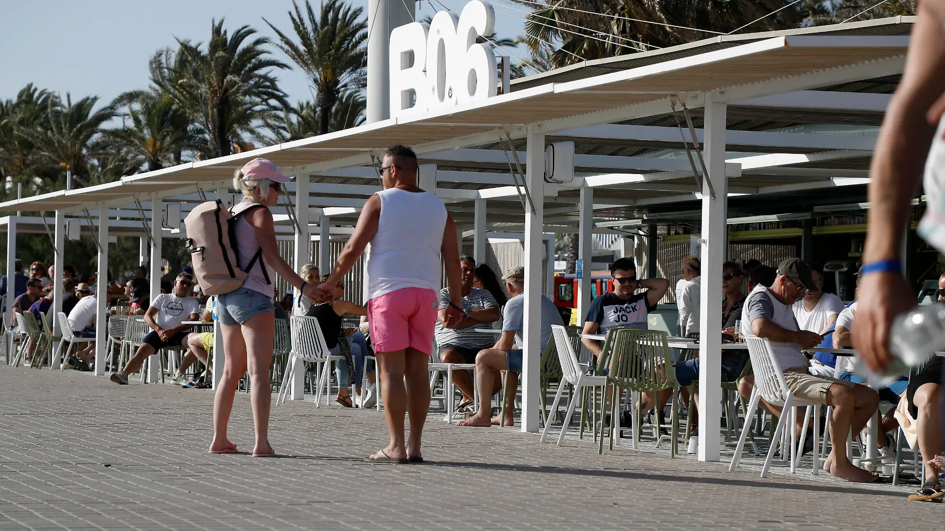 13.05.2022, Spanien, Palma: Menschen gehen am Ballermann 6 am Strand von Arenal vorbei. Der Ballermann auf Mallorca feiert sein 50-jähriges Jubiläum. Foto: Clara Margais/dpa +++ dpa-Bildfunk +++