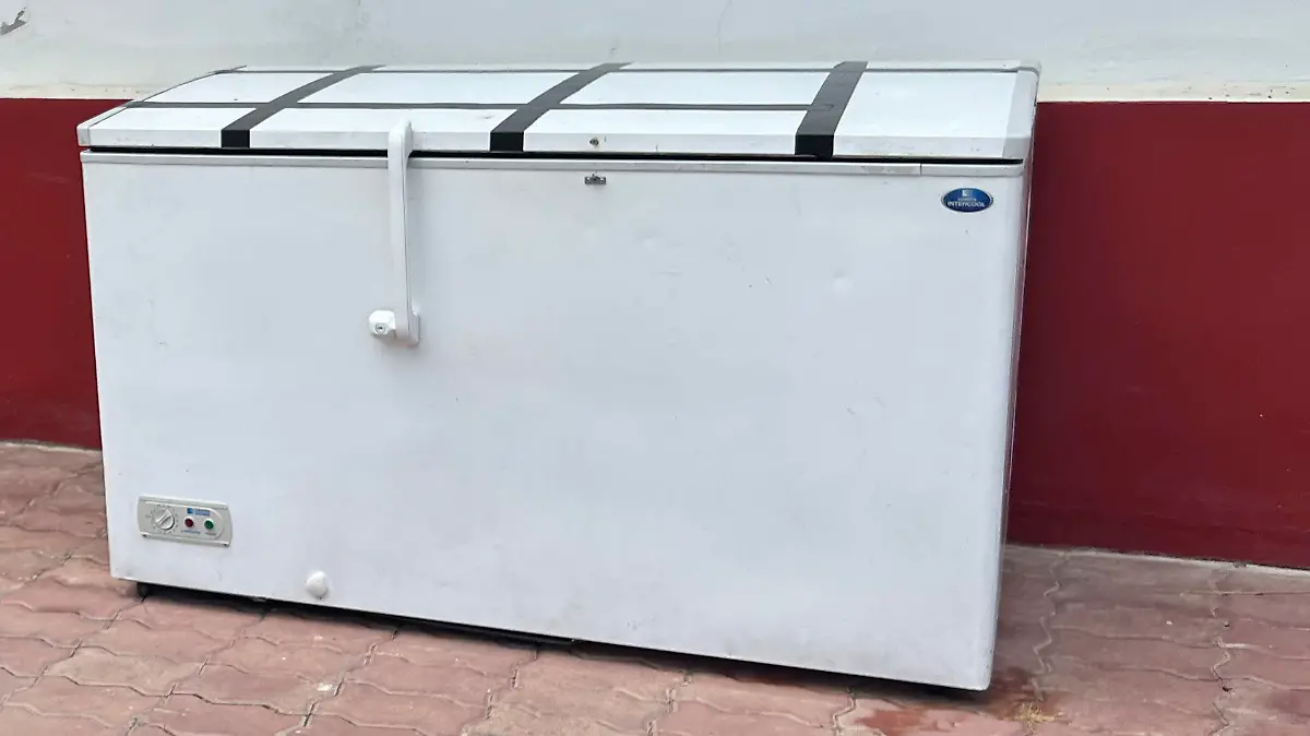 A Thai reporter takes a photo of an empty freezer at the Nong Prue police station in Pattaya, Chonburi province, Thailand, Tuesday, July 11, 2023. The dismembered body of a 62-year-old German businessman Hans-Peter Mack who has been missing for a week has been found in the freezer of a house in southern Thailand, police said Tuesday. (AP Photo)