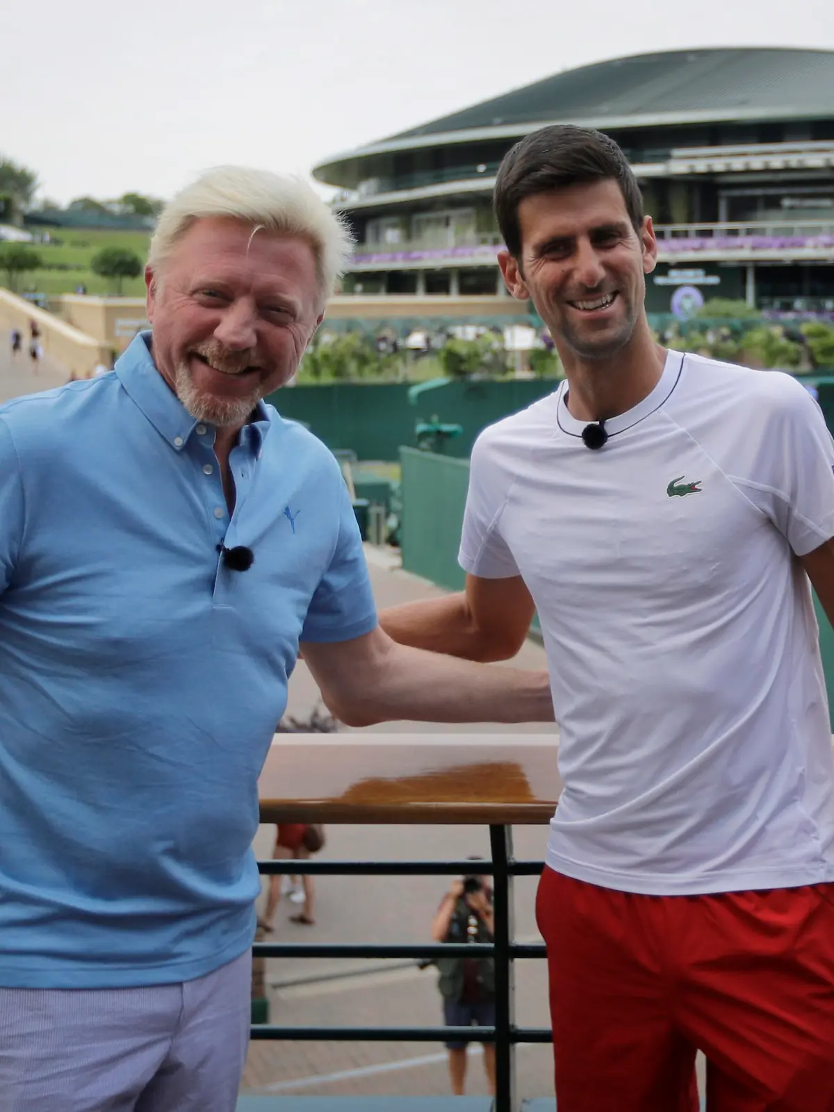 Novak Djokovic of Serbia, right, poses for a television camera during an interview with former tennis champion Boris Becker, left, ahead of the start of the Wimbledon Tennis Championships in London, Sunday, July 1, 2018. The Championships will start on Monday, July 2. (AP Photo/Ben Curtis)