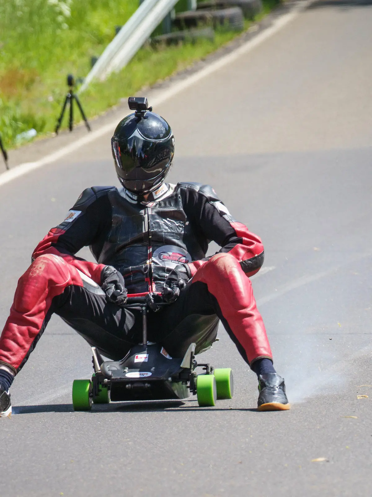 28.05.2022, Hessen, Schotten: Der Hesse Marcel Paul rast im Ortsteil Sichenhausen mit seinem modifizierten Bobbycar den Hang hinunter und bremst mit qualmenden Schuhen. Nach zwei Probeläufen erreichte der 29-Jährige mit 130,7 Stundenkilometern einen Geschwindigkeitsrekord, wie die Organisatoren berichteten. Foto: Frank Rumpenhorst/dpa +++ dpa-Bildfunk +++