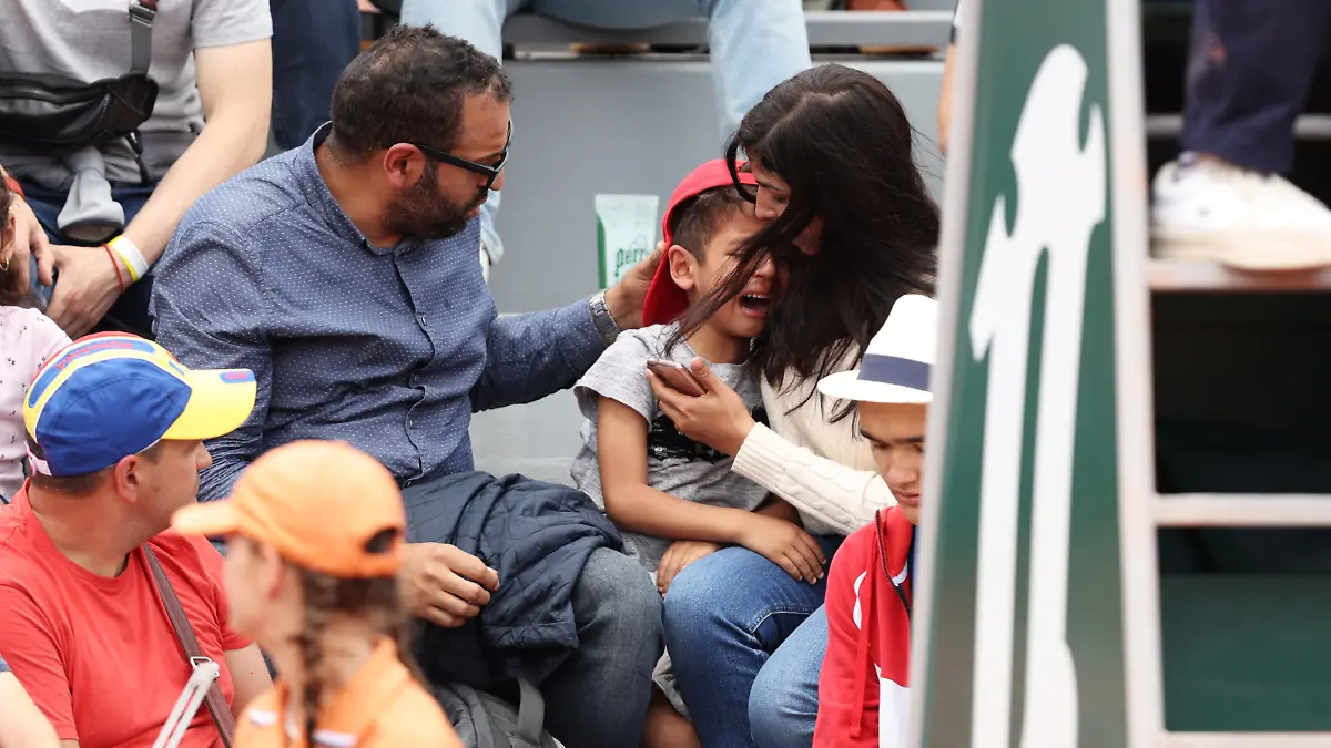 PARIS, FRANCE - MAY 26: Parents comfort their child after they were struck in the face by a ball hit by Irina-Camelia Begu of Romania during the Women's singles Second Round on Day Five of the 2022 French Open at Roland Garros on May 26, 2022 in Paris, France. (Photo by Clive Brunskill/Getty Images)