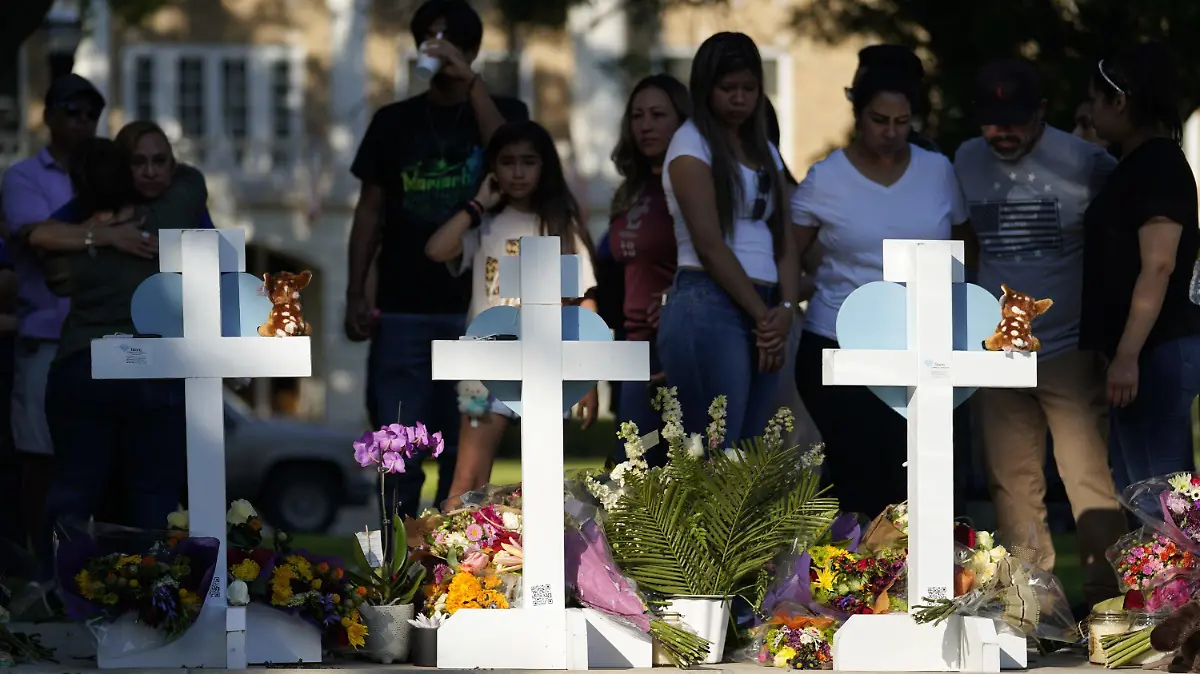26.05.2022, USA, Uvalde: Menschen trauern um die Opfer des Massakers an einer Grundschule in Uvalde, sie stehen vor Kreuzen mit Herzen, die im Gedenken an die Opfer aufgestellt wurden. Ein 18 Jahre alter Schütze hatte am Dienstag in der Kleinstadt Uvalde 19 Schulkinder und zwei Lehrkräfte erschossen. Foto: Wu Xiaoling/XinHua/dpa +++ dpa-Bildfunk +++