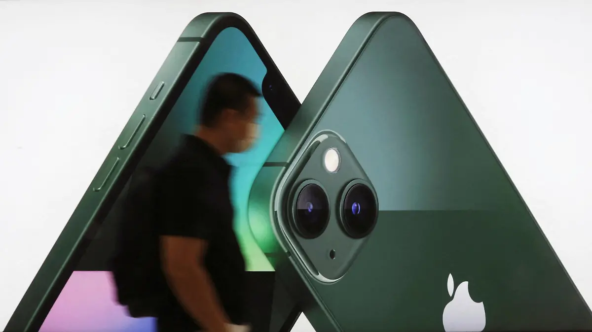 FILE PHOTO: A customer passes an Apple iPhone 13 advertisement at an Apple shop in Singapore on March 18, 2022. REUTERS/Edgar Su/File Photo