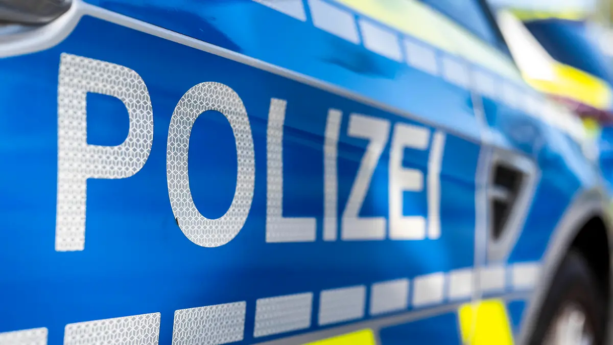ILLUSTRATION - 28.09.2021, Nordrhein-Westfalen, Gütersloh: An der Tür von einem Streifenwagen steht der Schriftzug «Polizei». (zu dpa: «84-Jährige zu Hause überfallen - Hilfe über mobilen Notruf gerufen») Foto: David Inderlied/dpa +++ dpa-Bildfunk +++