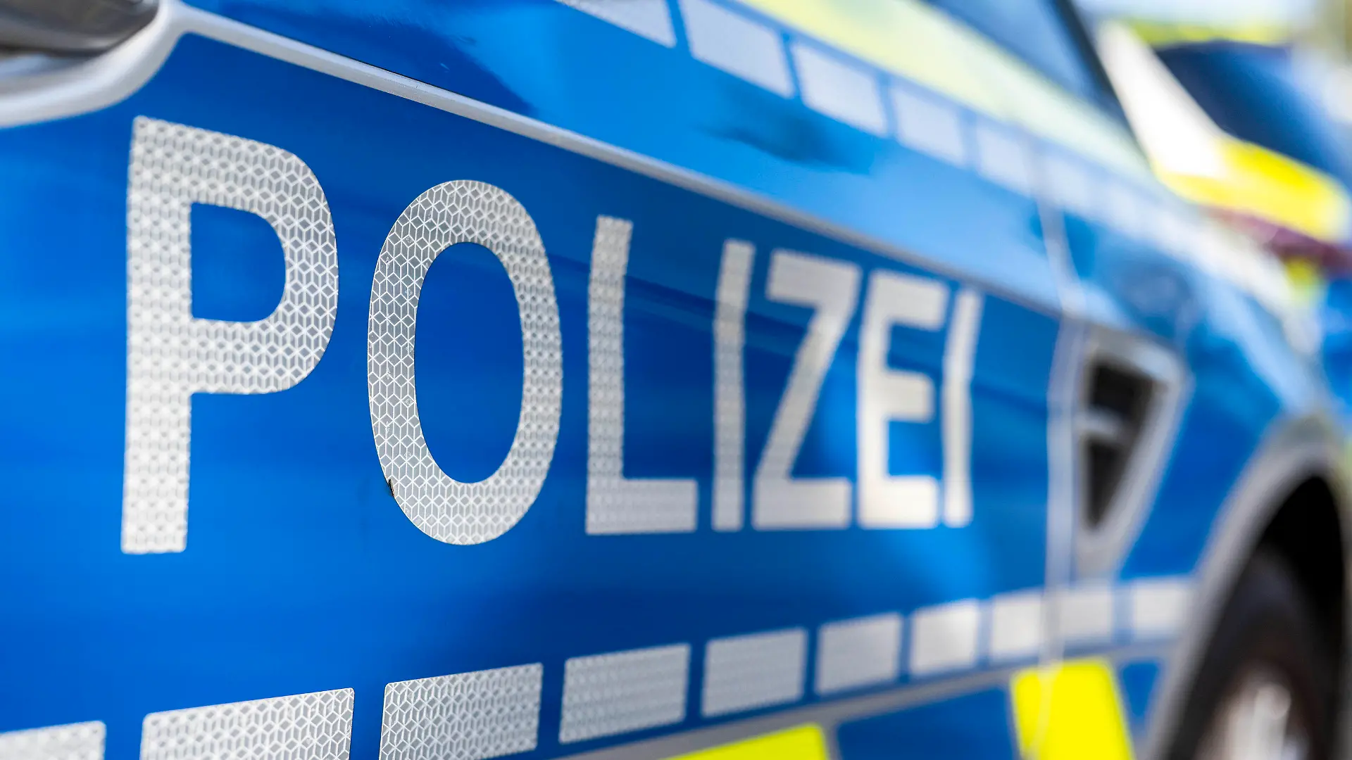 ILLUSTRATION - 28.09.2021, Nordrhein-Westfalen, Gütersloh: An der Tür von einem Streifenwagen steht der Schriftzug «Polizei». (zu dpa: «84-Jährige zu Hause überfallen - Hilfe über mobilen Notruf gerufen») Foto: David Inderlied/dpa +++ dpa-Bildfunk +++