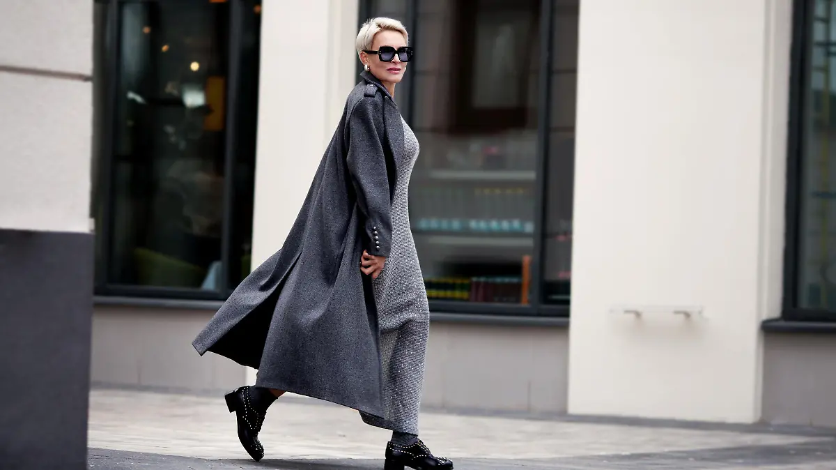 Frau trägt schickes Maxikleid mit Jacke und Sonnenbrille.