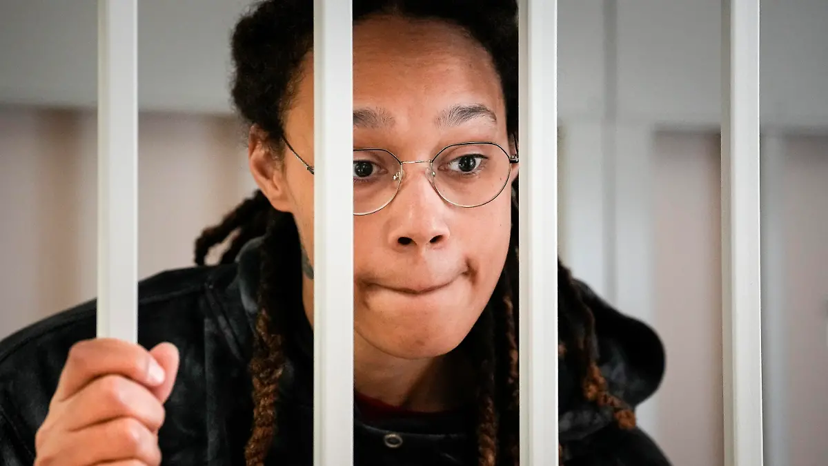 FILE - WNBA star and two-time Olympic gold medalist Brittney Griner speaks to her lawyers standing in a cage at a court room prior to a hearing, in Khimki just outside Moscow, Russia, on July 26, 2022.  Russia has freed WNBA star Brittney Griner on Thursday in a dramatic high-level prisoner exchange, with the U.S. releasing notorious Russian arms dealer Viktor Bout. (AP Photo/Alexander Zemlianichenko, Pool, File)