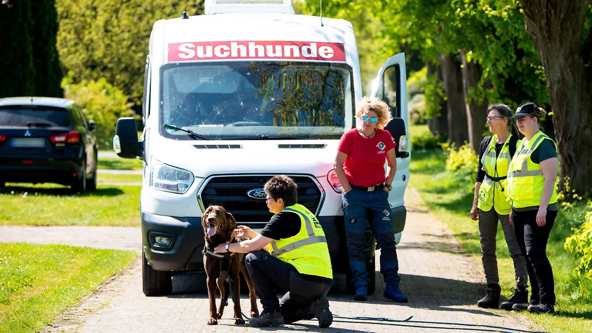 01.05.2024, Niedersachsen, Behrste: Ein Hund der K-9 Suchhunde Elbe-Weser wird für die Suche nach einem vermissten Jungen in einem Wohngebiet vorbereitet. Der sechs Jahre alte Arian aus Elm bleibt auch nach über einer Woche vermisst. Foto: Daniel Bockwoldt/dpa - ACHTUNG: PKW-Kennzeichen wurde aus rechtlichen Gründen gepixelt +++ dpa-Bildfunk +++