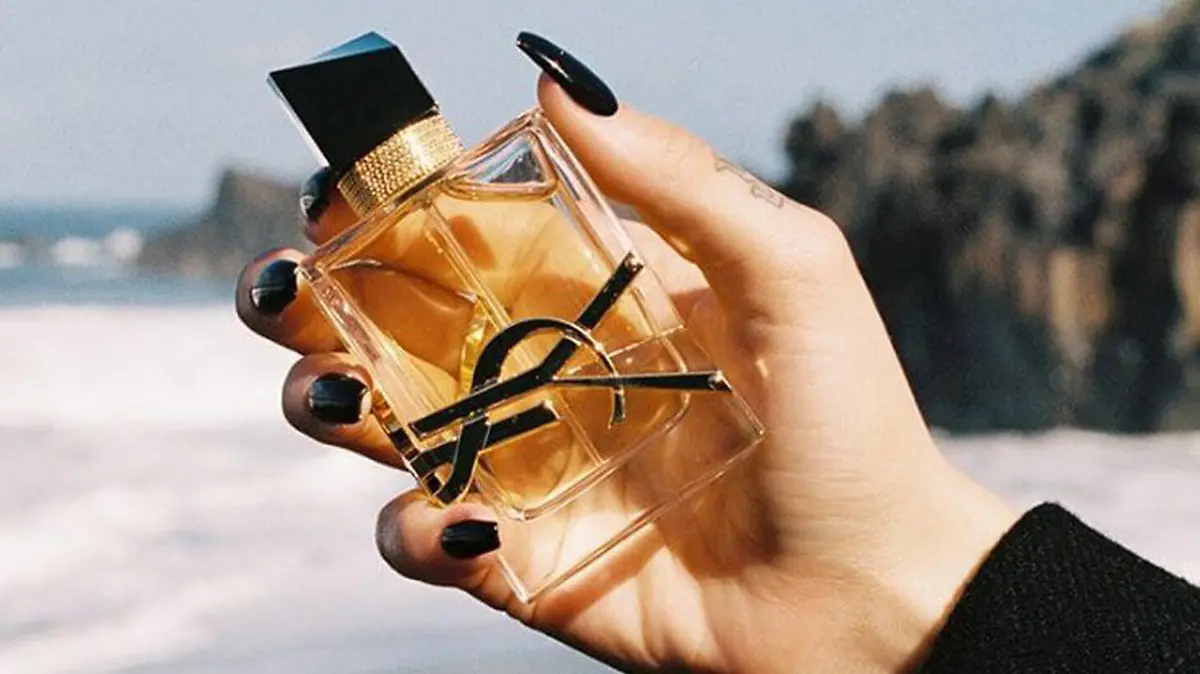 Frau hält Libre von Yves Saint Laurent.