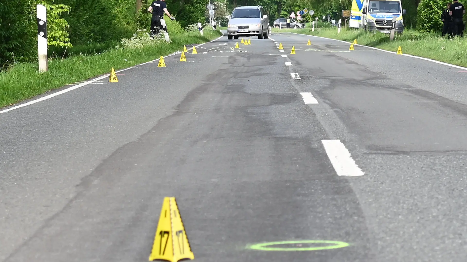 04.05.2024, Nordrhein-Westfalen, Dorsten: Markierungen der Polizei stehen an der Stelle, an der ein Fußgänger vermutlich von einem unbekannten Auto erfasst und getötet wurde. Ein 21-jähriger Fußgänger ist nach einem Unfall im Kreis Recklinghausen tot auf der Straße liegend gefunden worden. Ein Autofahrer hatte die Leiche am frühen Samstagmorgen in Dorsten-Lembeck gefunden, wie die Polizei mitteilte. Foto: Guido Bludau/dpa +++ dpa-Bildfunk +++