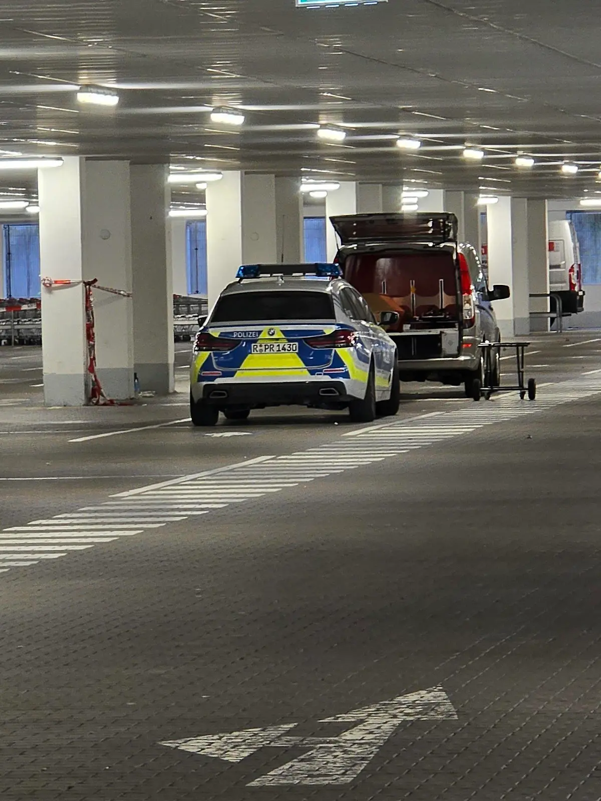 04.05.2024, Bayern, Regensburg: Einsatzkräfte der Kriminalpolizeiinspektion Regensburg arbeitet in einer Tiefgarage eines Baumarkts. Am Vormittag wurde in der Garage die Leiche einer Frau im Kofferraum eines Autos gefunden. Die Polizei ermittelt, wie die junge Frau aus dem Landkreis Cham ums Leben gekommen ist, so ein Sprecher. Foto: Moller-Schuh/vifogra/dpa - ACHTUNG: VERWENDUNG NUR IN DEUTSCHLAND *** Usage only in Germany *** +++ dpa-Bildfunk +++
