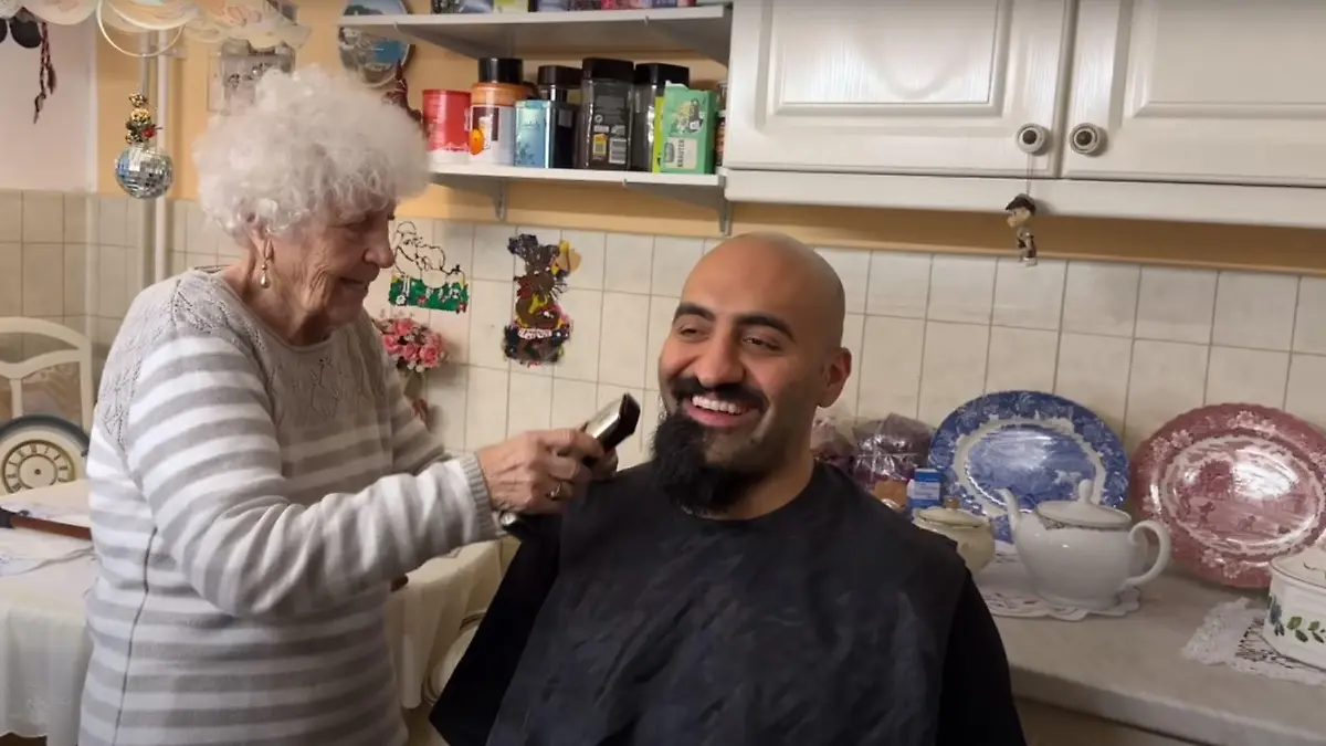 Patientin Oma Lotti rasiert Pfleger Rashid Hamid den Bart ab