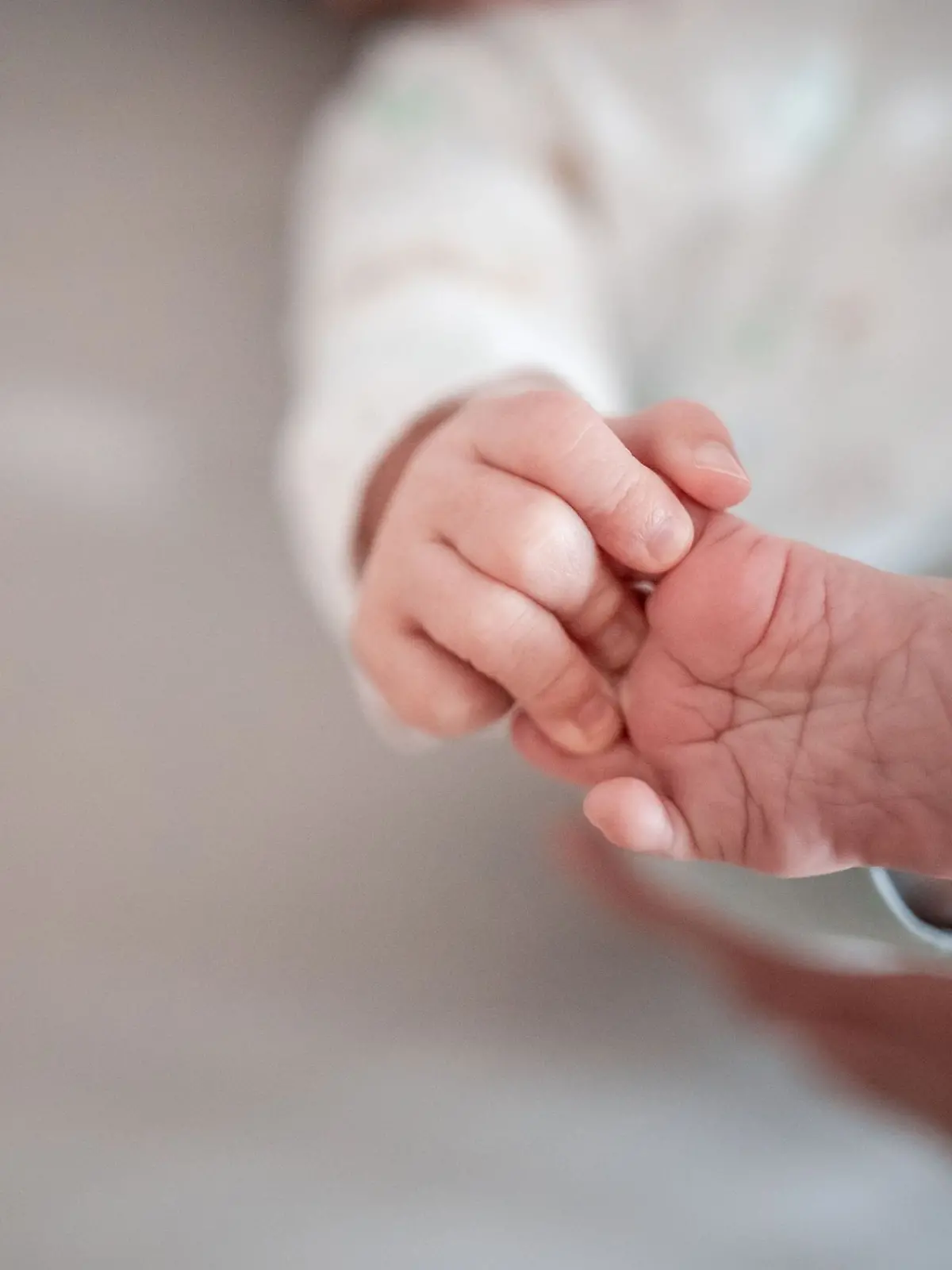 Ein Baby greift mit den Fingern nach seinem Fuß.