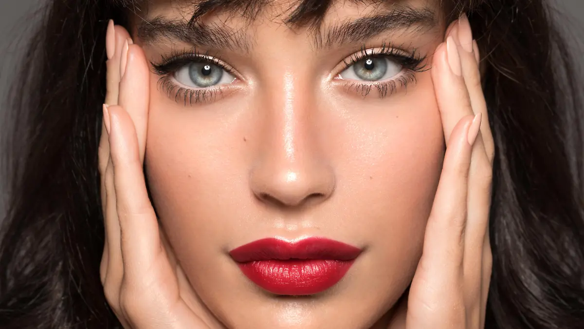 Close up studio shot of a beautiful woman with perfect skin, she touching her face