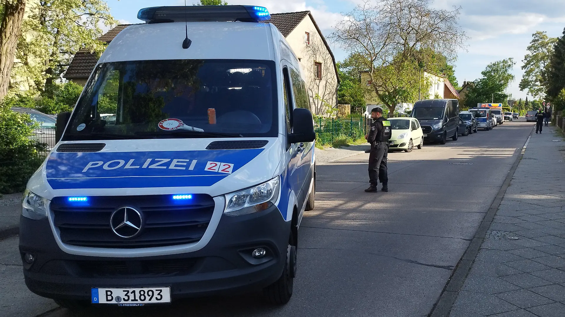 06.05.2024, Berlin: Polizisten sperren eine Straße im Berliner Bezirk Spandau für die Ermittlungsarbeiten. Nach dem Tod eines Mannes auf offener Straße im Berliner Bezirk Spandau ermittelt eine Mordkommission. Ersten Ermittlungen zufolge bestehe der Verdacht eines Tötungsdelikts. Foto: Christian Pörschmann/dpa +++ dpa-Bildfunk +++