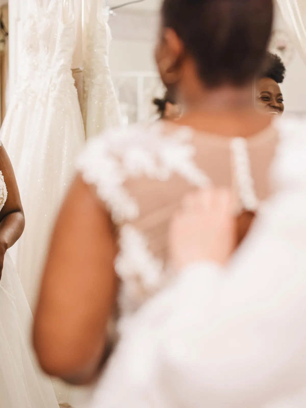 The future bride looks around the shop and tries on wedding dresses in the presence of her best friends. Lifestyle shopping concept, post-Covid-19 era