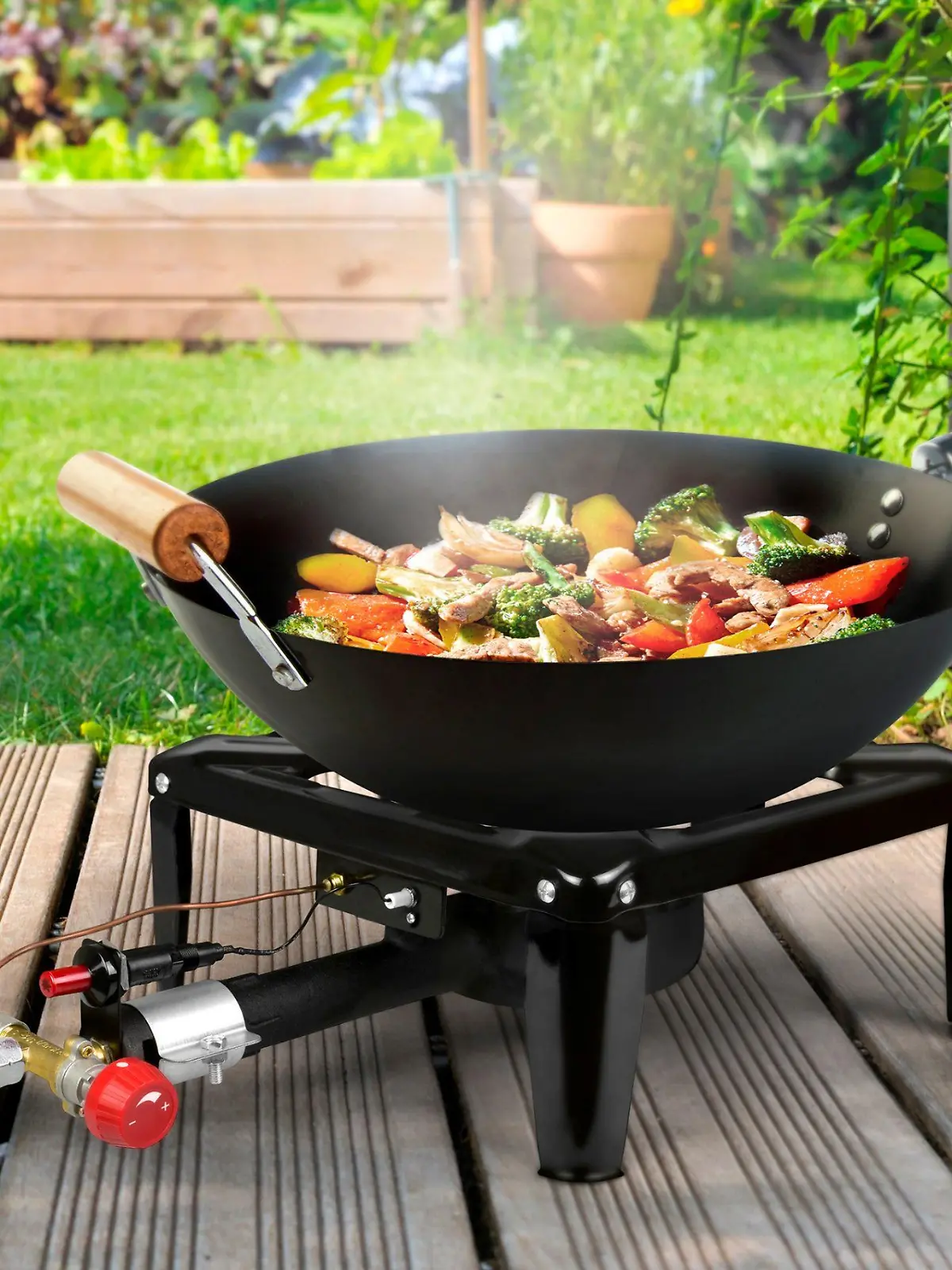 Eine Wok-Pfanne auf einem Gaskocher im Garten,