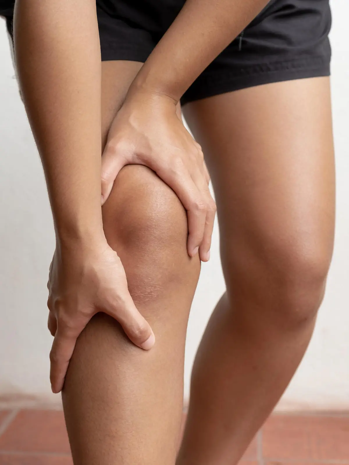 Woman hand massage physiotherapy her knee is sore and numb, exhausted, tingling. Guillain-Barre Syndrome, a side effect of the Covid vaccination.