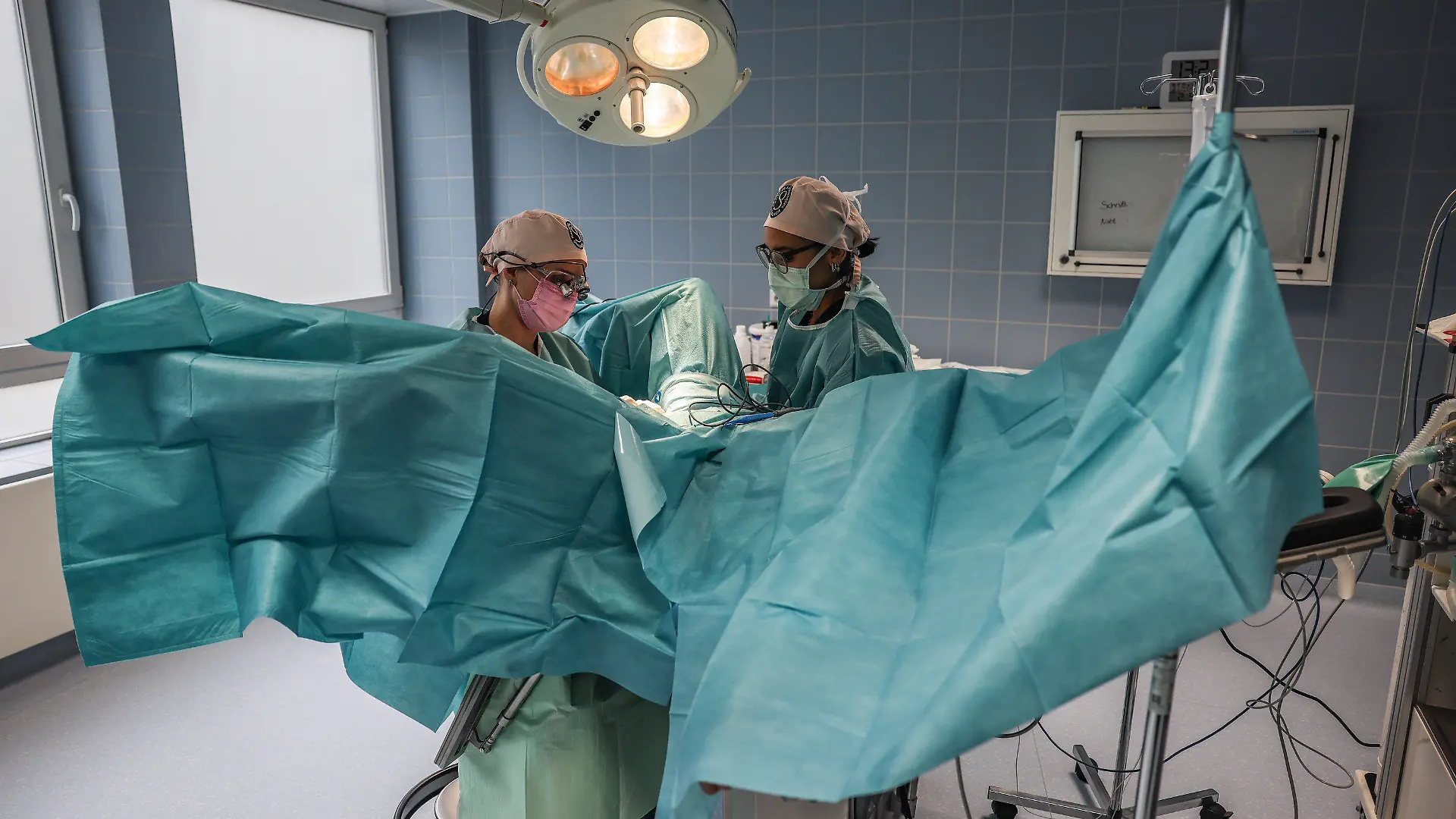PRODUKTION - 02.05.2023, Nordrhein-Westfalen, Köln: Pirkko Schuppan (l), Ärztin für Intimchirurgie, führt im Operationssaal mit einer OP-Schwester zusammen eine Schamlippen-Operation durch. (Zu dpa "Zweifelhaftes Ideal: Vom Trend zum korrigierten Intimbereich") Foto: Oliver Berg/dpa +++ dpa-Bildfunk +++