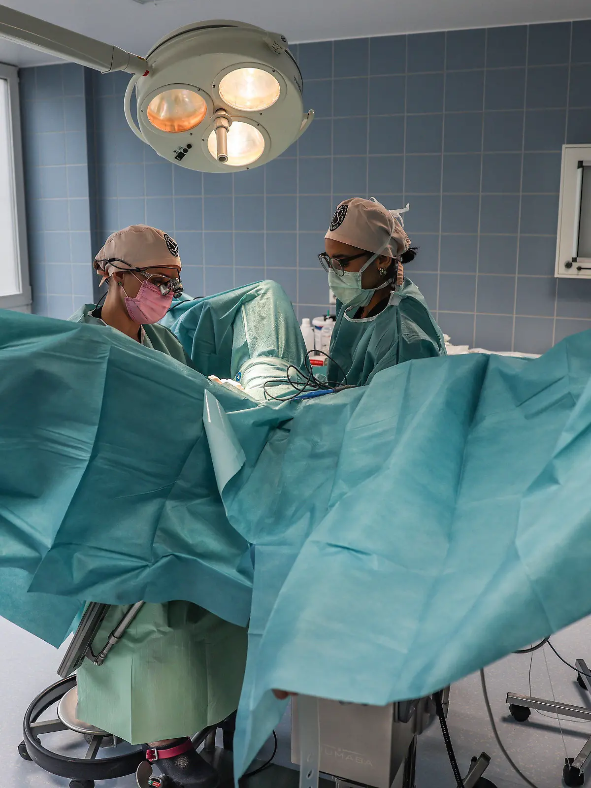 PRODUKTION - 02.05.2023, Nordrhein-Westfalen, Köln: Pirkko Schuppan (l), Ärztin für Intimchirurgie, führt im Operationssaal mit einer OP-Schwester zusammen eine Schamlippen-Operation durch. (Zu dpa "Zweifelhaftes Ideal: Vom Trend zum korrigierten Intimbereich") Foto: Oliver Berg/dpa +++ dpa-Bildfunk +++