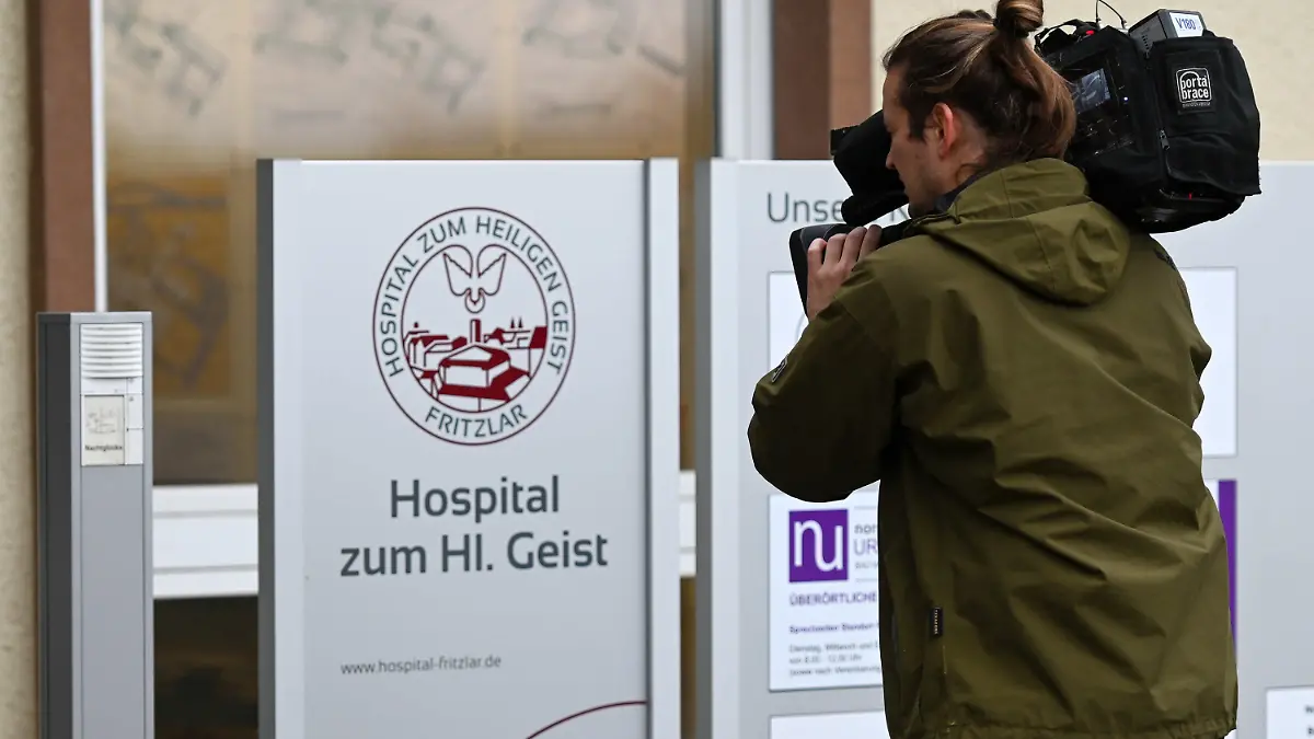 01.11.2019, Hessen, Fritzlar: Ein Kameramann filmt das Schild am Haupteingang der Klinik "Hospital zum Heiligen Geist". Eine mutmaßlich falsche Ärztin soll in der Klinik ohne entsprechende Ausbildung Patienten betäubt haben. Laut Staatsanwaltschaft starben vier Menschen. Nun sitzt die Frau in Untersuchungshaft. Foto: Uwe Zucchi/dpa +++ dpa-Bildfunk +++