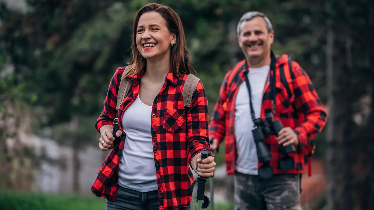 Two people, senior father and daughter going hiking in nature together.