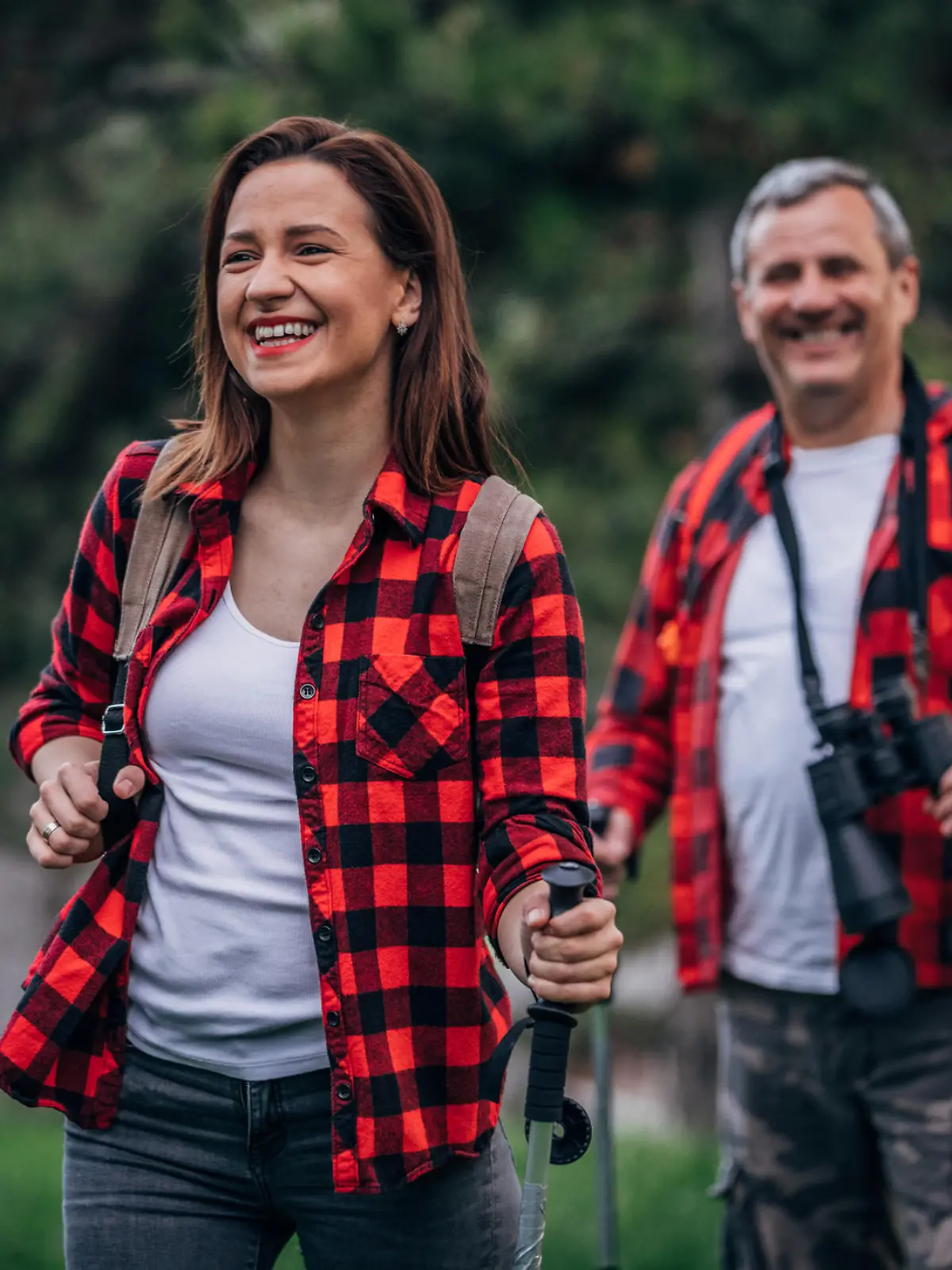 Two people, senior father and daughter going hiking in nature together.