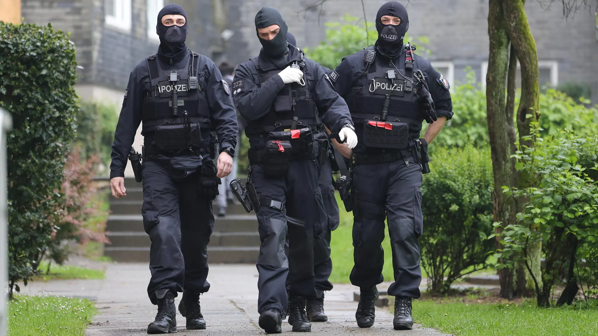 07.05.2024, Nordrhein-Westfalen, Solingen: Eine Gruppe vermummter Polizisten beim Einsatz vor Wohnhäusern. Wegen eines mutmaßlichen Sexualdeliktes an einer 16-Jährigen hat die Polizei am Dienstag (07.05.2024) vier Wohnungen von verdächtigen jungen Männern in Solingen durchsucht. (zu dpa: «Verdacht auf Sexualdelikt an 16-Jähriger - vier Wohnungen durchsucht») Foto: Gianni Gattus/dpa +++ dpa-Bildfunk +++