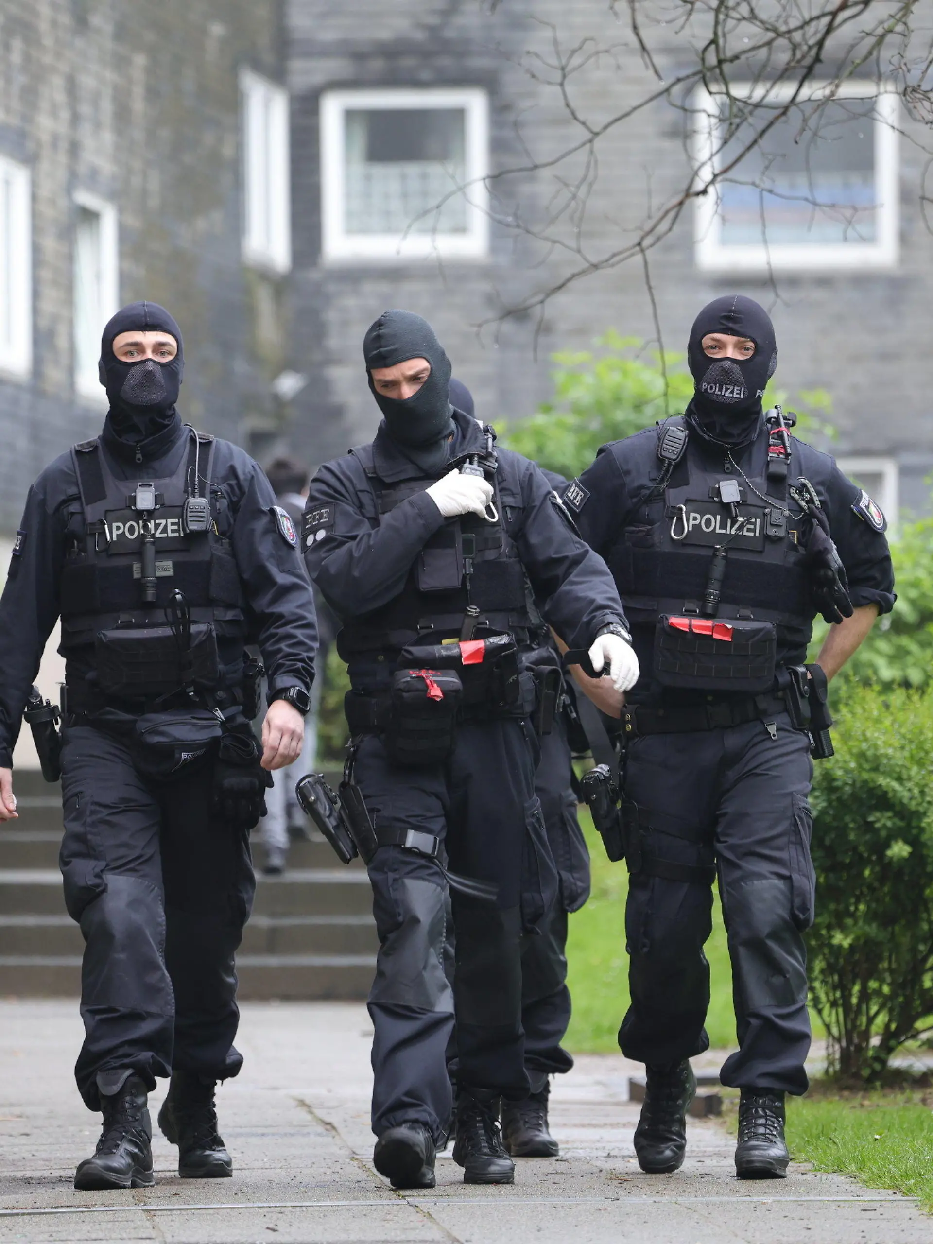 07.05.2024, Nordrhein-Westfalen, Solingen: Eine Gruppe vermummter Polizisten beim Einsatz vor Wohnhäusern. Wegen eines mutmaßlichen Sexualdeliktes an einer 16-Jährigen hat die Polizei am Dienstag (07.05.2024) vier Wohnungen von verdächtigen jungen Männern in Solingen durchsucht. (zu dpa: «Verdacht auf Sexualdelikt an 16-Jähriger - vier Wohnungen durchsucht») Foto: Gianni Gattus/dpa +++ dpa-Bildfunk +++