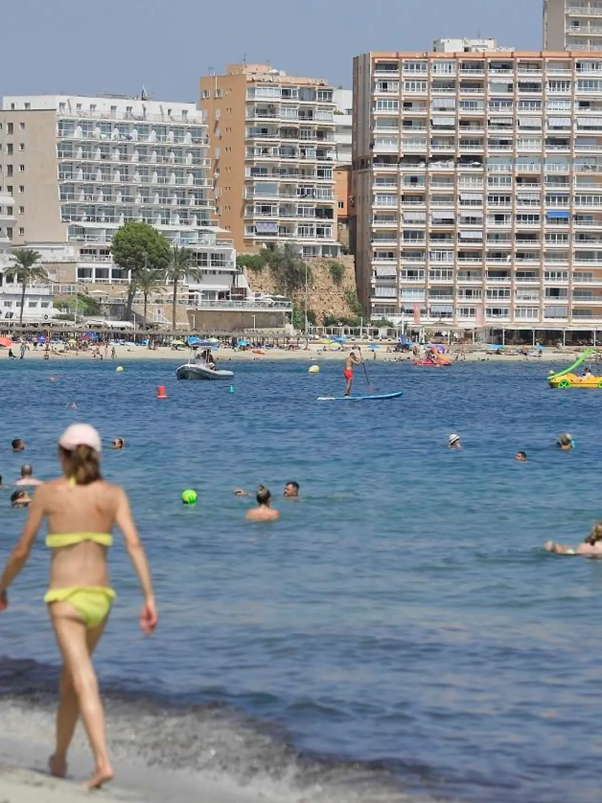 Menschen genießen den Tag am Strand in Magaluf. Polizei und Justiz müssen sich auf Mallorca erneut mit einer mutmaßlichen Gruppenvergewaltigung beschäftigen.